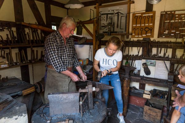 Vorführung im Metallhandwerksmuseum Steinbach-Hallenberg: Schmied zeigt Besucherinnen traditionelle Schmiedekunst.