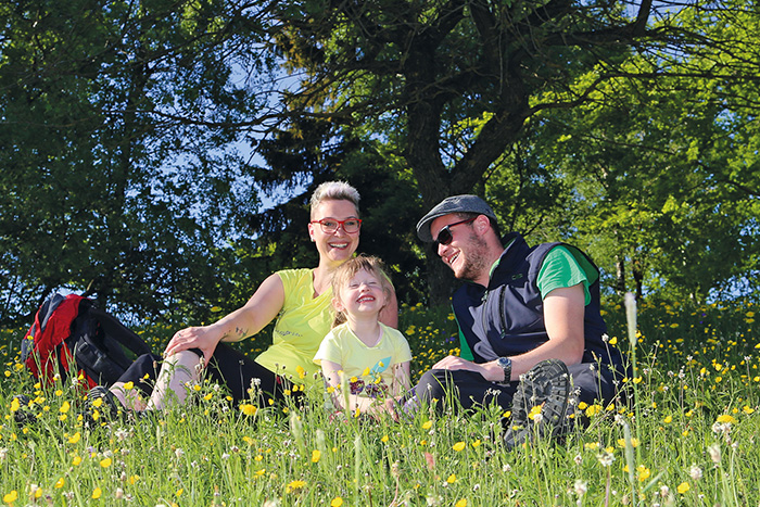 Familie mit Kind sitzen im Grünen