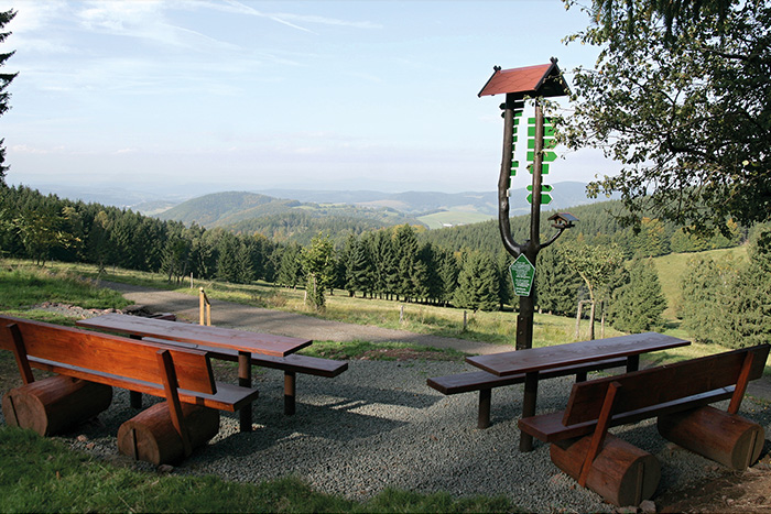 Sitzgruppe und Wegweiser für Wanderer mit einem Blick auf den Thüringer Wald