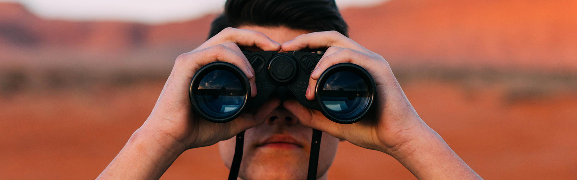 Fundbüro, Mann schaut durch ein Fernglas