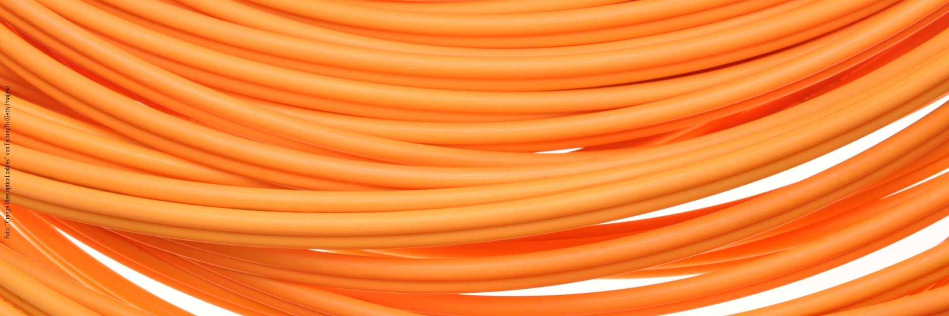 Mehrere orangefarbene Glasfaserkabel in Nahaufnahme.