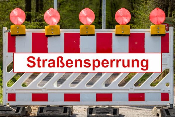Straßensperrung mit rot-weißer Absperrung und fünf Warnleuchten