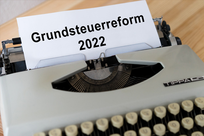 Schreibmaschine mit eingelegtem Blatt und der Aufschrift Grundsteuerreform 2022